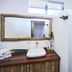 Otro Lado Lodge And Restaurant bathroom sink with rustic wood-framed mirror and tiled shower, Santa Teresa