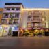 Hotel Waves, New Delhi, exterior at dusk beside OPO Hotels and The Piano storefront