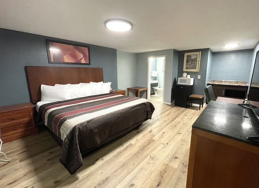 Annie Oakley Motel Oakley guest room with king bed, desk, and light wood flooring