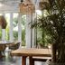 Kimpton Aluna Tulum dining area with wicker chairs, wooden tables and tropical plants in Tulum