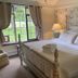 Maxwelton Braes Lodge in Baileys Harbor: cozy bedroom with four-poster bed and green countryside view