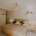 Hotel Cielo y Selva guest room with king bed, bedside tables, wall mirror and hanging lamp in San Cristóbal de las Casas