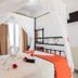 Hotel Lodos in Karterados: white-canopy bed with towel swan and orange throw in a bright guest room