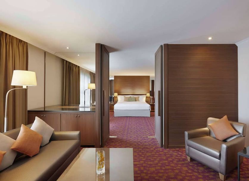 Dusit Princess Srinakarin Bangkok hotel suite with seating area and bedroom in Bangkok