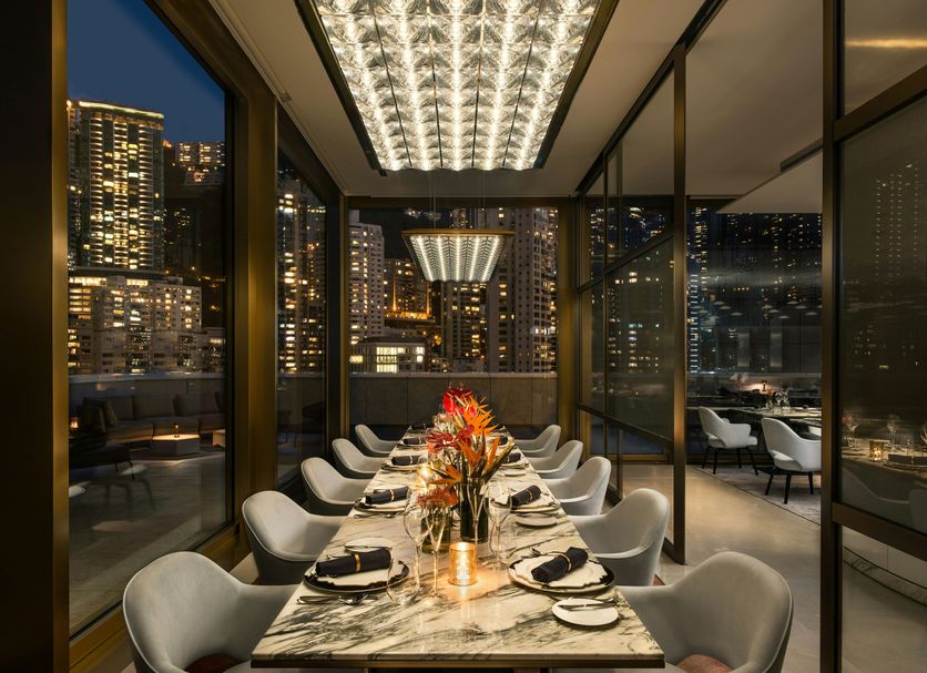 The Murray, Hong Kong, a Niccolo Hotel dining room with glass walls and city skyline views at night