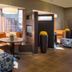 Courtyard by Marriott Cleveland Beachwood lobby with curved seating, round tables, and tall planter accents