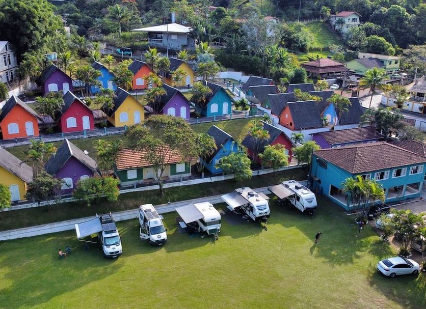 Hotel Vale Verde Penedo in Penedo with colorful cottages, green lawn, and hillside views