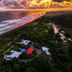 Aerial view of Hotel Cocomar Beachfront Hotel in Parrita beside a tropical beach at sunset