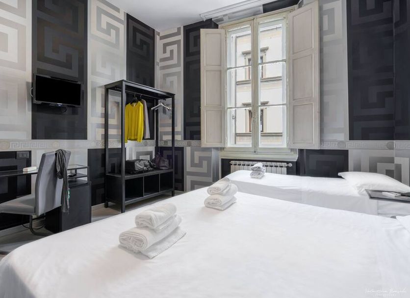 Hotel Spagna, Florence: twin guest room with patterned walls, two beds, desk, and tall windows