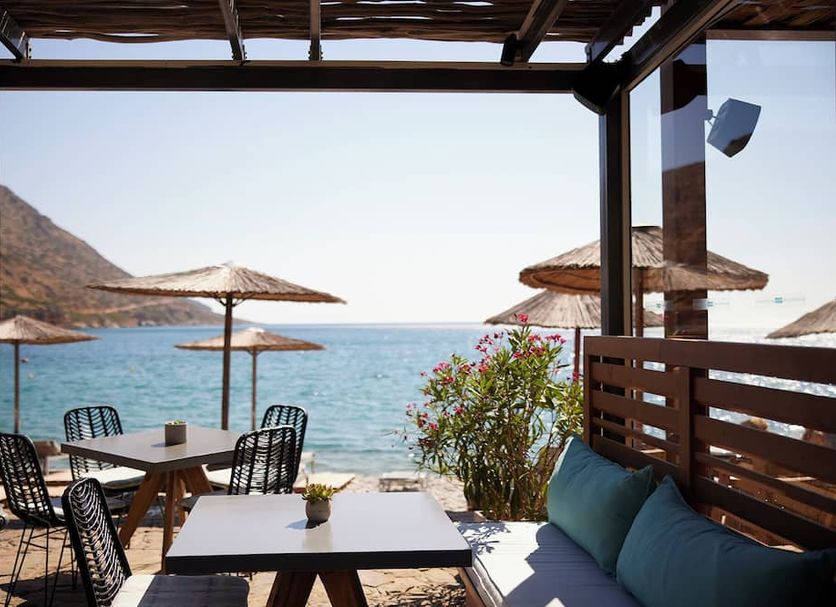 Cayo Exclusive Resort & Spa in Elounda with seaside terrace tables, umbrellas, and sea view