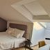 Vila Lili in Rovinj: loft bedroom with double bed, teal chair, skylight and sloped ceiling