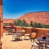 Ksar Ighnda in Aït Ben Haddou terrace with tables, potted flowers, and desert mountain views
