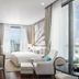 137 Pillars Residences Bangkok hotel suite with city view, bed, armchair and floor-to-ceiling windows