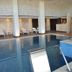 Indoor pool and spa area at Rayentray Grand Hotel in Puerto Madryn with loungers and hot tub