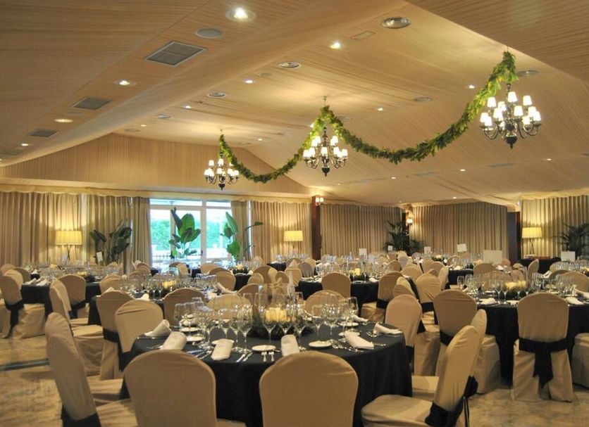 Arva Santiago León in León banquet hall with round tables, chandeliers and festive garlands