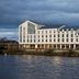 AC Hotels by Marriott Inverness on the riverfront under stormy skies, with large windows and waterside views