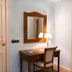 Hotel Horus Zamora in Zamora: a small desk with mirror, chair and lamp in a guest room corner