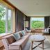 Hakodate-Onuma Prince Hotel in Nanae room with sofa, round table, TV, and forest view