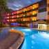 The Garden Hotel & Resort in Fort Lauderdale with illuminated pool and palm-lined exterior at dusk