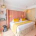 Golden Tulip Aix Les Bains guest room with king bed, yellow accents, and sitting area in Aix-les-Bains