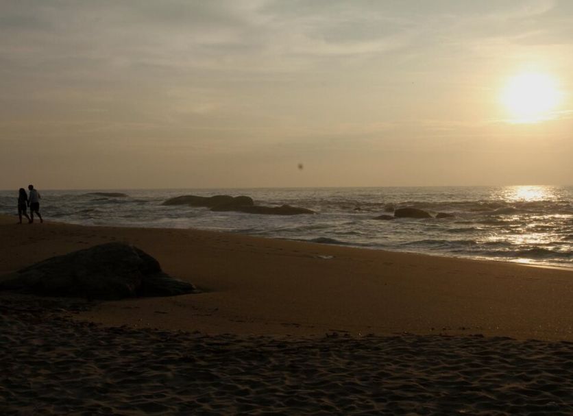 The Beach Camp Yala in Kirinda, beachfront sunset with ocean waves and two people on the sand