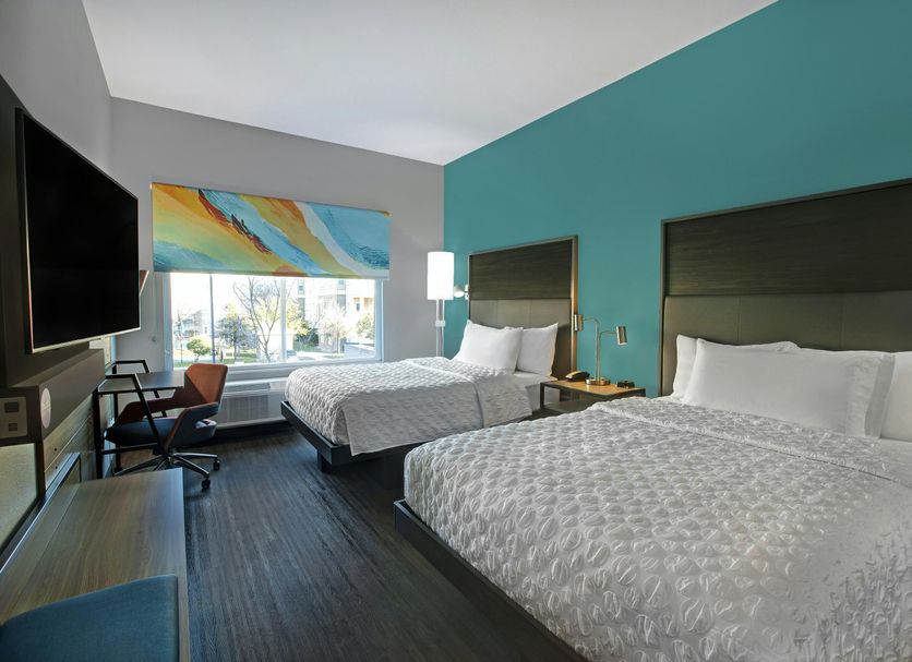 Tru by Hilton Austin Airport room with two beds, desk, window view, and teal accent wall in Austin