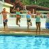 Guests jumping beside outdoor pool at Nader's Motel & Suites in Ludington