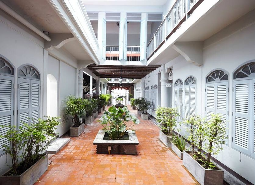 The Memory at On On Hotel Phuket City interior courtyard with terracotta tiles and potted plants