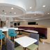 Hampton Inn by Hilton Hopewell Fort Lee lobby with turquoise bar stools, white tables, and curved booth seating