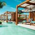 Jungala Hotel at VidantaWorld Riviera Maya in Cancún, beachfront pool with cabanas and palm trees