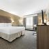 Best Western Brockport Inn & Suites room with king bed, desk, TV, and window seating in Brockport