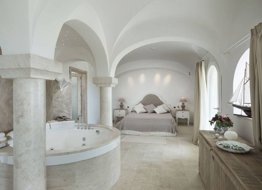 Hotel Pulicinu, Arzachena: arched suite with round bathtub, king bed and nautical decor