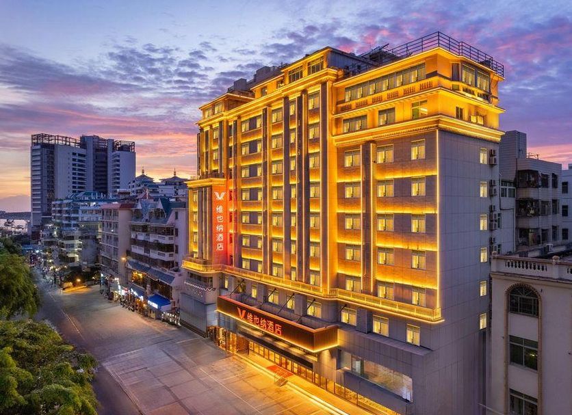 Vienna Hotel Sanya Bay No.1 in Sanya at dusk, exterior lit with city street view