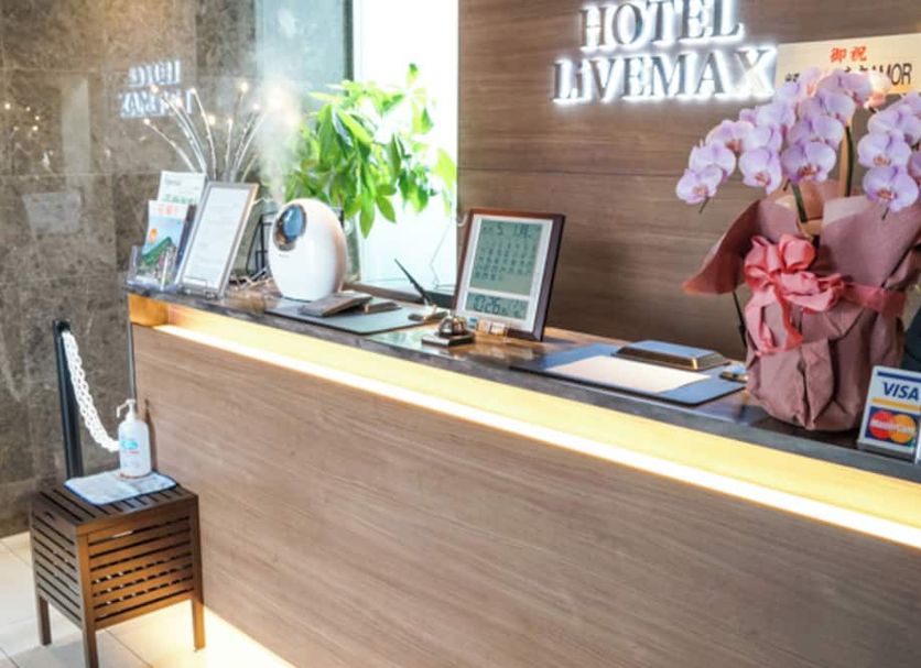 Hotel Livemax Saitama-Asaka-Ekimae front desk with orchid arrangement in Asaka