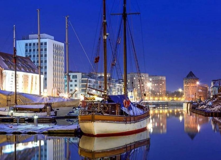 Marina Club Hotel in Gdansk with harbor marina boats and city lights reflecting on calm water