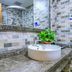 Education Hotel Guilin bathroom vanity with round sink, marble counter, tiled walls and mirror