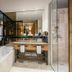 Almwellness Hotel Pierer in Fladnitz bathroom with bathtub, double vanity and glass shower