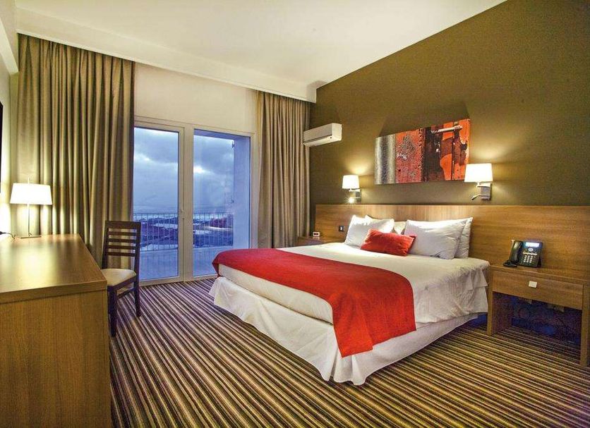 Hotel Antofagasta in Antofagasta guest room with king bed, balcony doors and city view