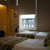 Abberley House in Carlisle guest room with two beds and a window view of nearby buildings