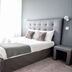 Hôtel L'Europe in Cholet: modern guest room with double bed, gray headboard, and desk by window