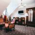 Arensburg Boutique Hotel & Spa in Kuressaare: attic lounge with striped chairs, TV, desk and lamp