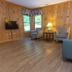 Carter Caves State Resort room in Olive Hill with wood-paneled walls, armchairs, lamps and wall-mounted TV.