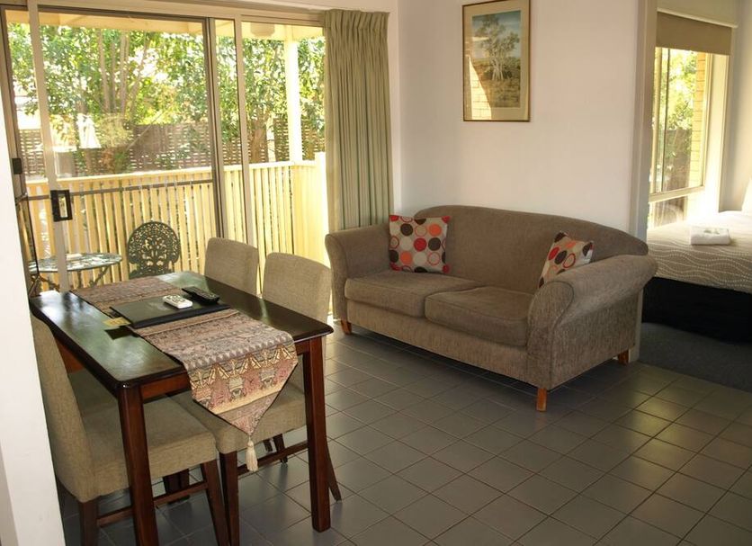 Old Coach Motor Inn Echuca room with dining table, sofa, bed and sliding glass doors