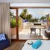Hotel Son Caliu Spa Oasis in Palma Nova with terrace, lounge chairs and sea view through sliding doors