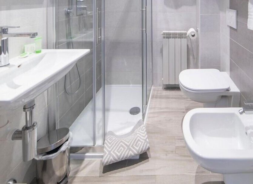 Albergo Pesce D'oro bathroom in Verbania with glass shower, wall-mounted toilet and bidet