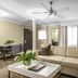 The Burgundy Hotel, Little Rock: bright suite with sectional sofa, coffee table, desk, and window curtains
