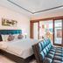 Kubu Petitenget Suite Seminyak in Kuta guest room with king bed, balcony and seating area