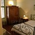 Agriturismo La Capitata room in Pian di Scò with wrought-iron bed, armoire and bedside lamp