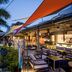 Hennessy Park Hotel in Ebene terrace bar with outdoor seating, palm trees and colorful shade sails