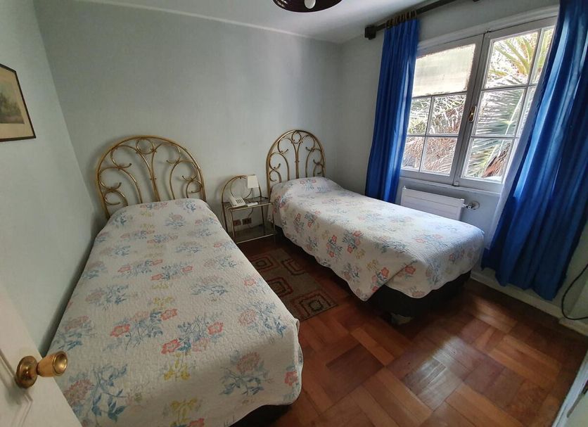 Hotel Foresta Santiago twin room with two single beds and window with blue curtains
